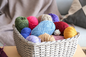 Fototapeta na wymiar Wicker basket with knitting yarn on wooden table