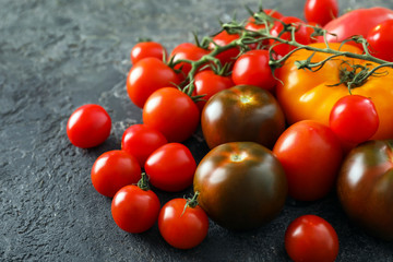 Fototapeta na wymiar Different fresh tomatoes on grey background