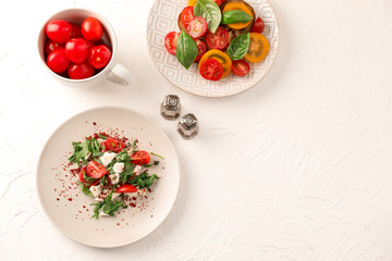 Composition with sliced tomatoes and fresh salad on light background
