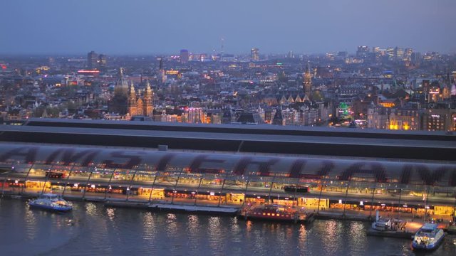 amsterdam skyline illuminated at night zoom out on train station