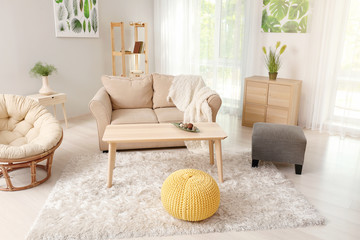 Fototapeta na wymiar Stylish interior of living room with comfortable sofa, armchair and table
