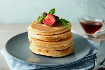 Plate with tasty pancakes and fresh strawberries on table