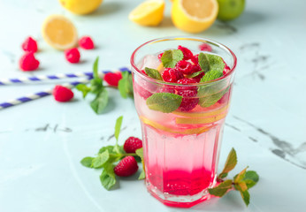 Glass of fresh raspberry mojito on table