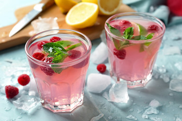 Glasses of fresh raspberry mojito on table