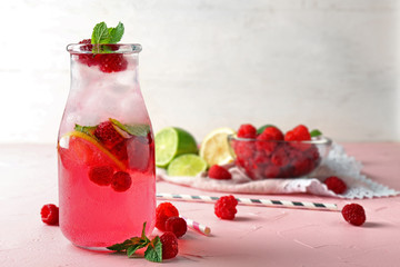 Bottle of fresh raspberry mojito on table