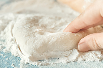 heart made of dough made by hand on table with flour