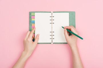 girl's hand writing in notepad