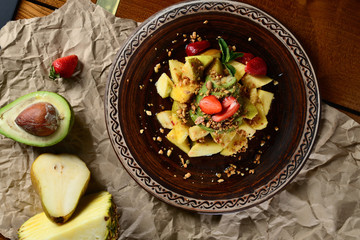 Mixed and assorted fruits with kiwi strawberry grape and other in bowl on wood table