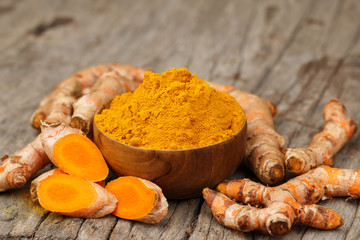 Turmeric powder in wooden bowls on wooden table
