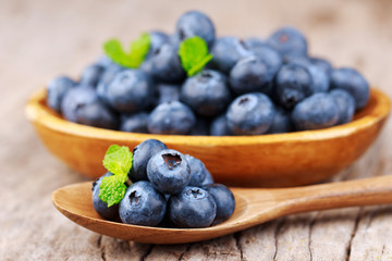 Blueberries in a wood bowl on a wooden table, Healthy eating and nutrition concept