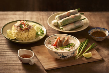 Assorted asian dinner, vietnamese food. Chicken rice, bun cha ca, noodles, spring rolls