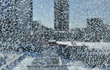 cracks broken glass of window on blur background of winter cityscape