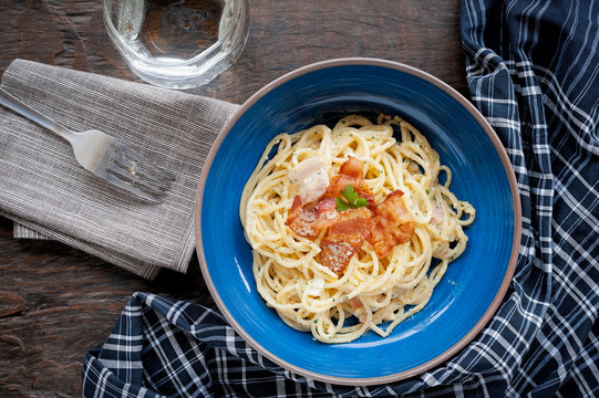 Tradition Italian food pasta carbonara, Spaghetti with bacon, ham and parmesan cheese on wooden table.