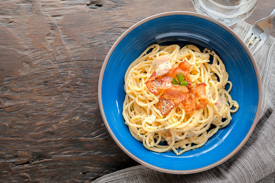 Tradition Italian food pasta carbonara, Spaghetti with bacon, ham and parmesan cheese on wooden table.