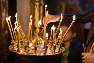 the believer puts a candle on the candlestick in the church