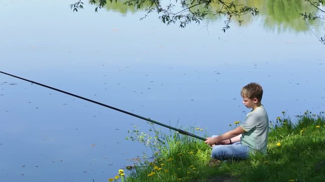 Young kid fishing on river in scenic place. Happy family on summer vacation in countryside concept. Real time full hd video footage.