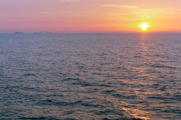 Sunrise in the waves of the sea. Sunset on the sea.