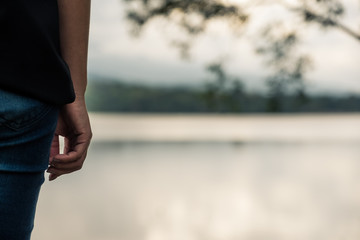Closeup image of a woman standing alone by the river