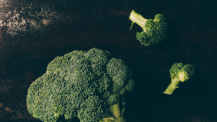 top view of green broccoli on grey dark table