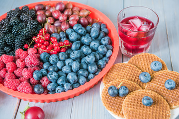 Different berries and wafers with cheese and a fruit cold drink.
