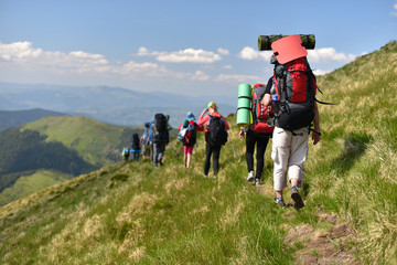 group hikers walking by mountains path