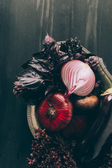 top view of basil, onions and eggplant on grey plate