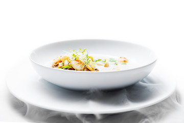 Cream mushroom soup with scallops, herbs, toast bread and dried ice mist.