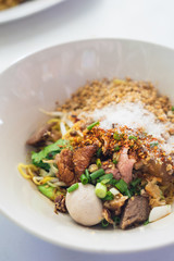 Close up of Thai Boat Noodles is noodles with pork and pork balls and black Soy Sauce.