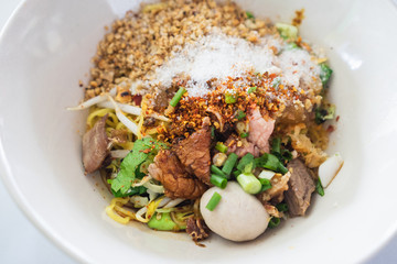 Close up of Thai Boat Noodles is noodles with pork and pork balls and black Soy Sauce.
