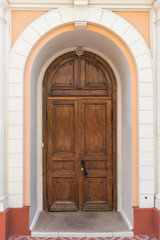 Wooden door of an old mansion with an arch