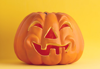 plastic halloween pumpkin on colorful background