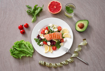 Composition with tasty diet food and measuring tape on grey background
