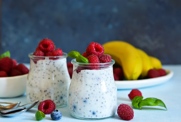 Vanilla yoghurt with raspberries and banana for breakfast. Dietary meals.
