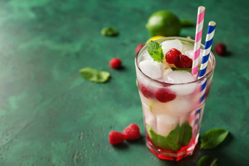 Glass of fresh raspberry mojito on table