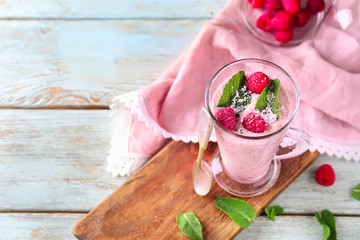 Glass with tasty raspberry smoothie on wooden table