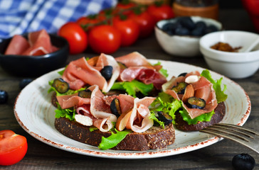 Toast of rye bread with jamon, blueberries and almonds. Snack with a proshoto!