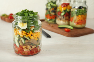 Delicious vegetable salad in mason jar on wooden table