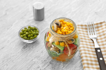 Delicious vegetable salad in mason jar on wooden table