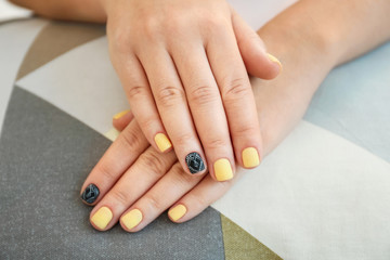 Female hands with stylish manicure on fabric, closeup