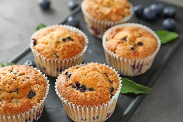 Tasty blueberry muffins on plate, closeup
