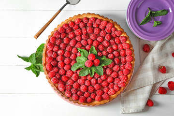 Tasty pie with fresh raspberries on white wooden table