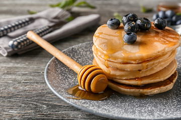 Plate with delicious pancakes and berries on wooden table, closeup