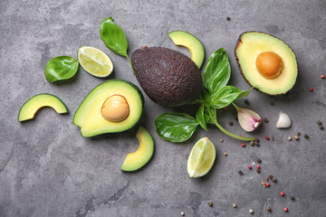 Composition with fresh ripe avocados on grey textured background