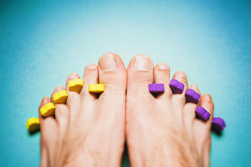 Male pedicure. Long toenails on a blue background.