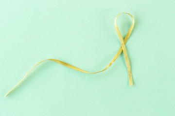 yellow, gold ribbon on a blue background, close-up, copy space, medical concept, Suicide Prevention Day