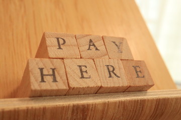 Wooden Block Text of Pay Here