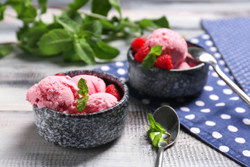 Bowls with delicious raspberry ice-cream on wooden table