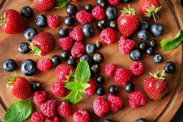Obraz na płótnie Canvas Delicious ripe berries on wooden board