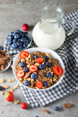 Healthy breakfast concept with oat flakes and fresh berries on rustic background. Food made of granola, muesli. Healthy banana smoothie with blackberries, muslie, strawberries, blueberries and honey.