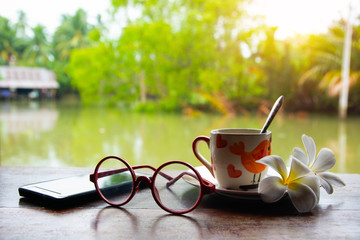 Canal lifestyle. Glasses of coffee, glasses, plumeria flowers are placed on the plate.
